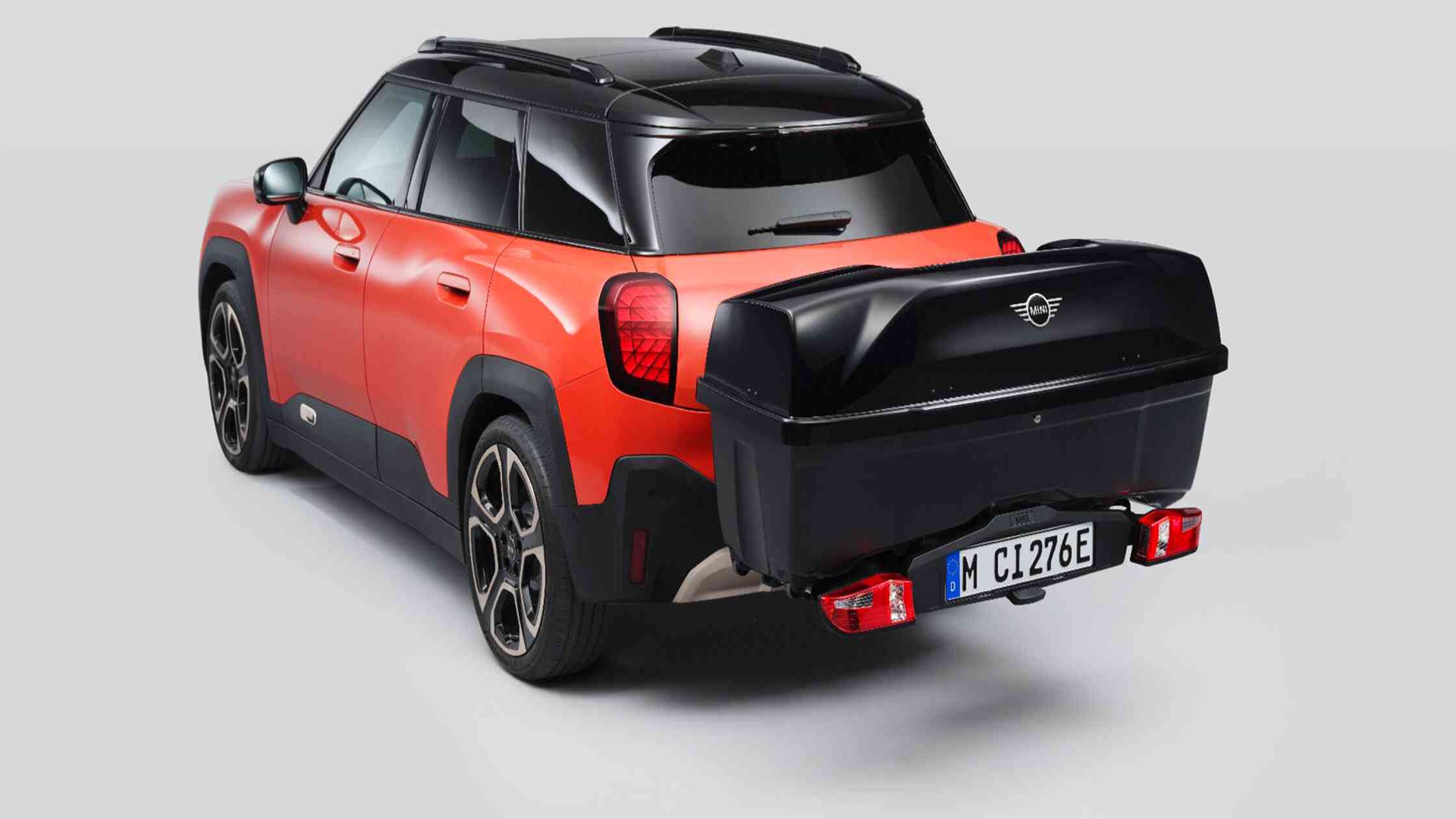 Rear side view of MINI Aceman in Nanuq White equipped with a MINI Rear Bike Rack and carrying the MINI Rear Box. 